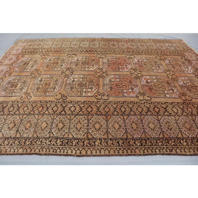 This exquisite vintage Turkoman tribal rug, hand-knotted in the 1950s in the Andkhoy village of Afghanistan, is a true...