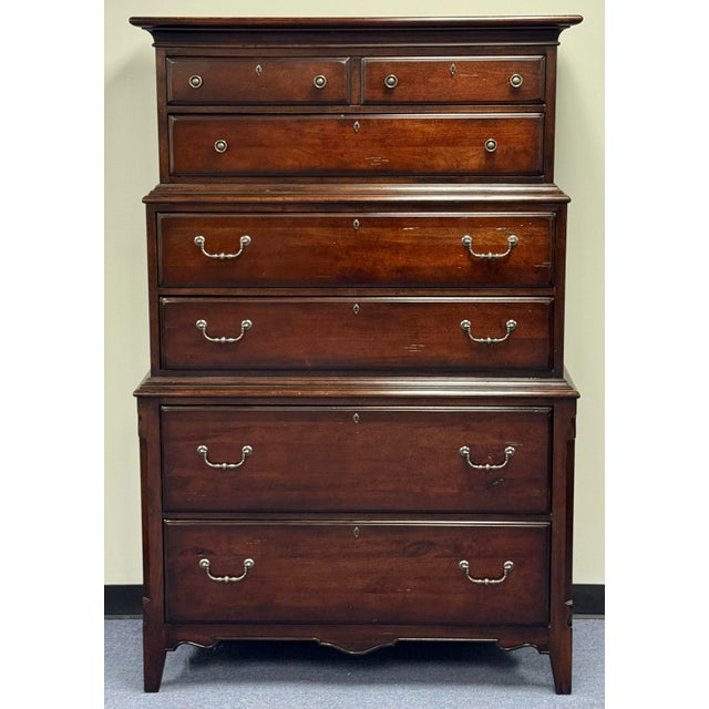 This rustic chest-on-chest features a classic multi-tiered design with a deep, dark reddish-brown stain that highlights...