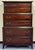 This rustic chest-on-chest features a classic multi-tiered design with a deep, dark reddish-brown stain that highlights...