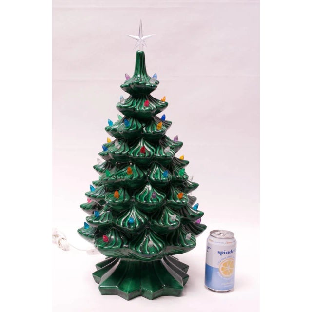 Circa 1970 illuminated ceramic Christmas tree with removable base. Adorned with a clear star. Additionally, the lights...