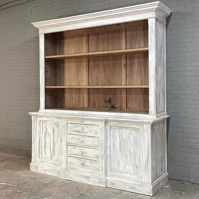 Grand 19th Century French Rustic Neoclassical Bookcase in Whitewashed Pine is a magnificent reminder of the grandeur of...