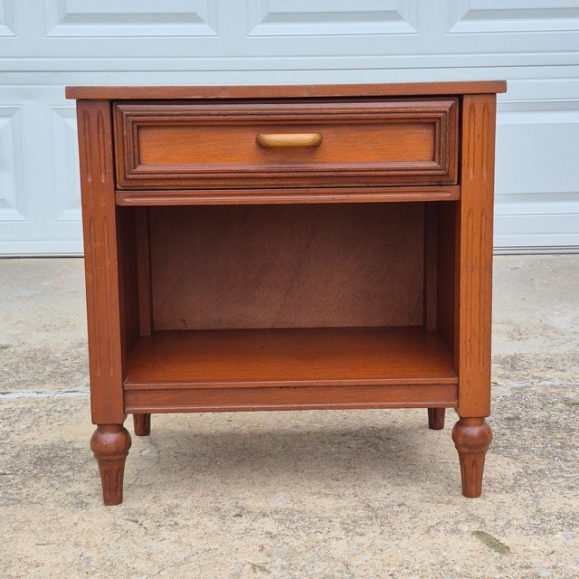 This is a mid-20th century Italian provincial style walnut veneer nightstand or side table with a single drawer and lower...