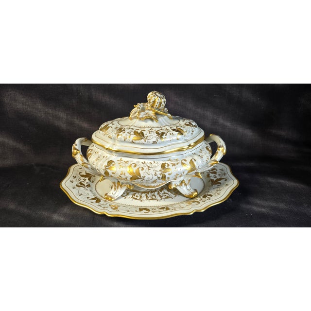 A painted and gilt porcelain tureen, with its matching stand, by le tallec, paris. the set features a decoration of gilt...