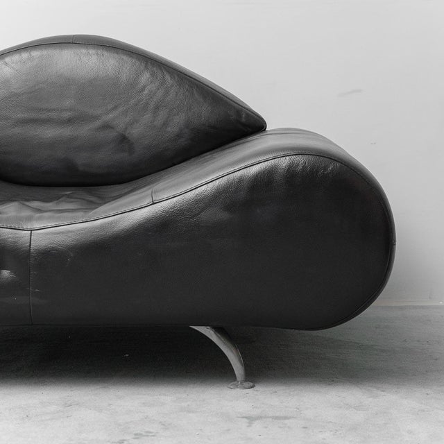 Modern-style armchair. Black leather upholstery. Metal legs. Signs of wear, as shown in photos.