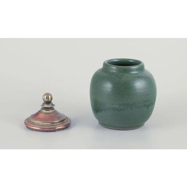Unique lidded ceramic jar. Glaze in green hues. Brass and bronze lid. Likely Danish ceramicist. Circa 1930s. Perfect...