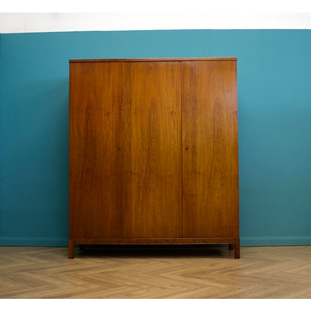 A freestanding solid superior quality Danish three door teak wardrobe, made during the 1960s. Fitted out with a satin...