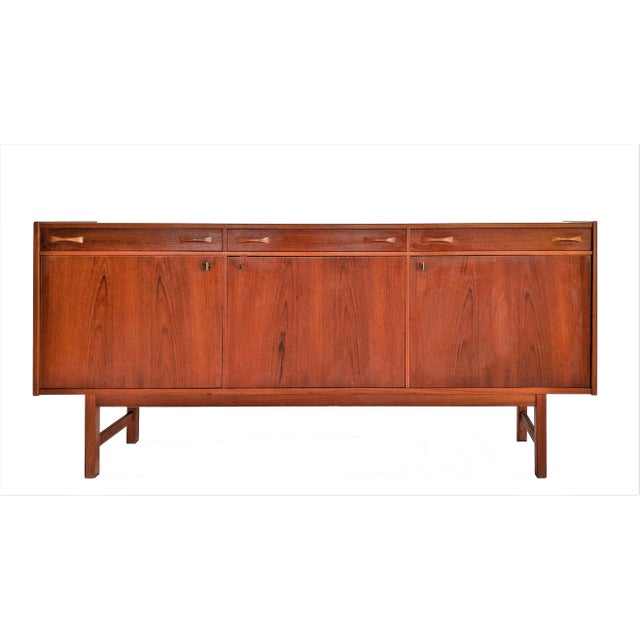 Ulferts Tibro Swedish Credenza circa 1960. Bowtie pulls on drawers and two brass keys which lock and open the doors.