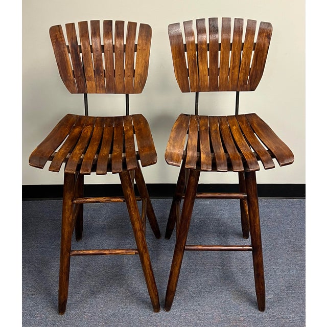 Pair of Vintage mid-century modern wooden slat and iron swivel bar stools attributed to designs by Arthur Umanoff from the...