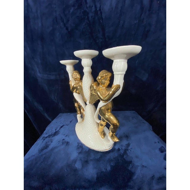 Exquisite Italian craftsmanship in this ornate candelabra! Warm golden angels wrap their delicate arms around white...