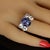 Gorgeous dinner featuring a clean sparkling blue-purply oval Tanzanite cabochon enhanced by two pairs of glittering...