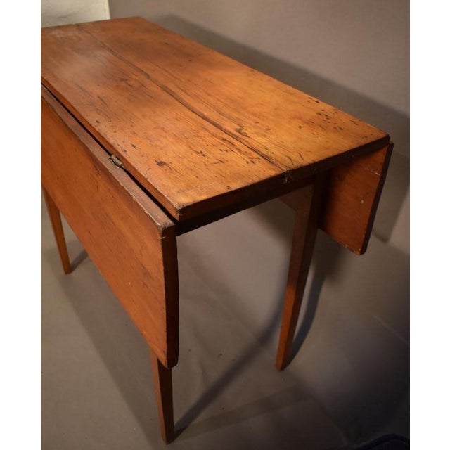 Pine American country Hepplewhite breakfast table with a plank to, circa 1785 to 1820. The overhang top rests on four...