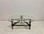 A striking postmodern coffee table in the manner of Jacques Adnet, designed by Jean-Pierre Ryckaert, combining industrial...