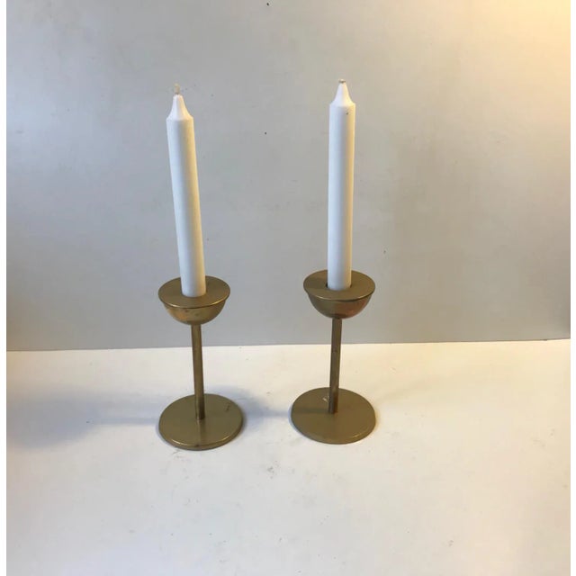 A pair of solid brass candlesticks manufactured by Cawa in Copenhagen, Denmark during the 1970s. The candlesticks are to...