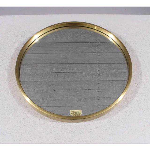 This elegant round brass mirror, model 132, was produced by Glas Mäster in Markaryd, Sweden, during the 1960s. It features...