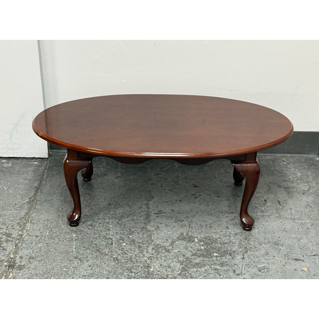 Design Plus Gallery presents the Queen Anne Style Coffee Table from The Bombay Company. An oval wood top, shaped edge, and...