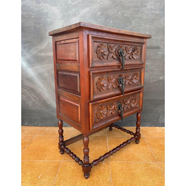 Spanish Renaissance Revival chest of drawers crafted in carved wood, dating to the mid-20th century. This piece features...