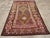 This early 20th-century Persian Kurdish accent rug presents a bold tribal composition in deep brown, magenta, rose,...