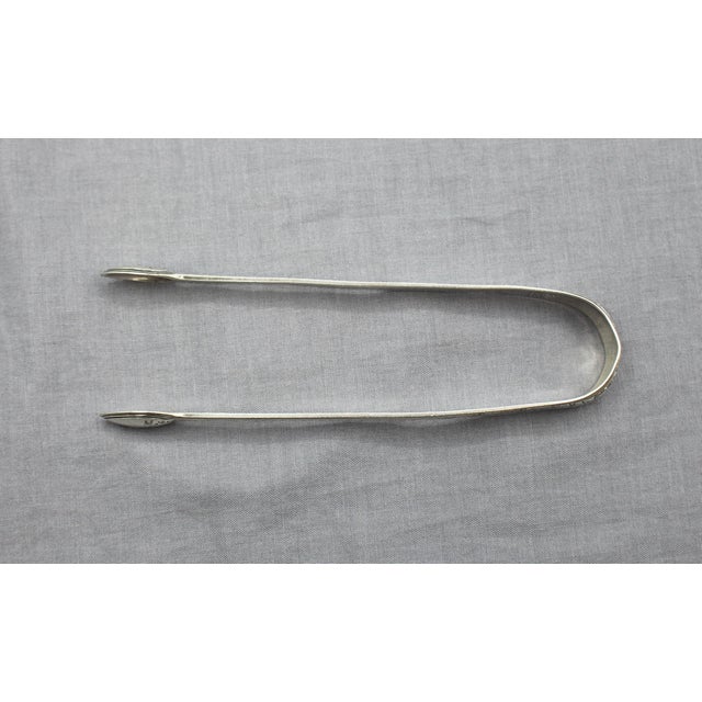 Sterling silver George III period sugar tongs, London, 1792. Elegant engraved floral motif, continued on the tips as well....