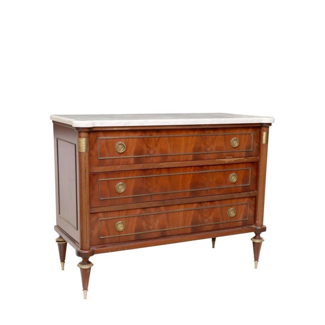 A gorgeous French Louis XVI Style Mahogany Marble Commode with design attributed to Maison Jansen Directoire Style. The...
