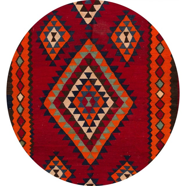 A beautiful hand-woven vintage kilim rug with a red field, an orange frame, and multi-color accents in an all-over...