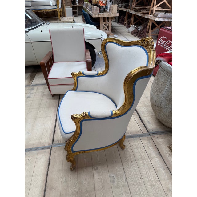 French armchair that has been reupholstered in white with a striking blue trim.