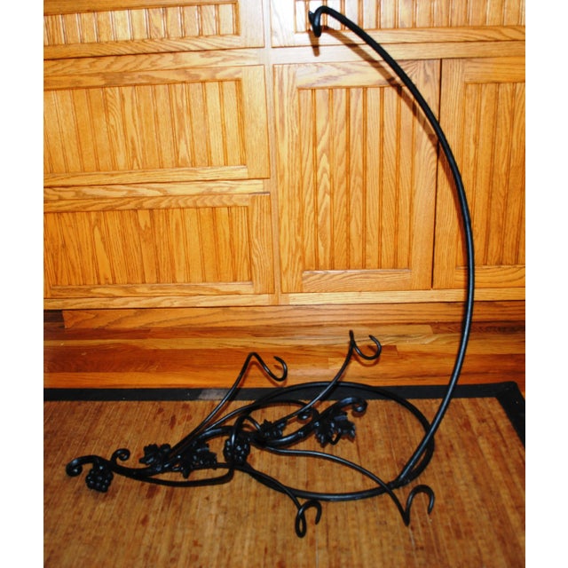 Hand Forged Articulating Floor Wine Rack. The rack hangs freely from a hooked stand. It holds up to 6 bottles of wine. It...