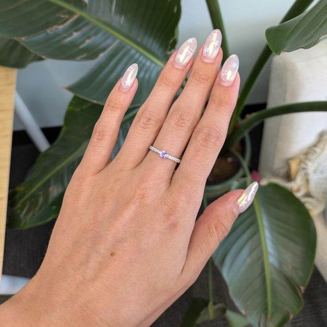 A natural purple sapphire sits at the heart of this round ring, surrounded by a sparkling halo of diamonds in solid 14K...