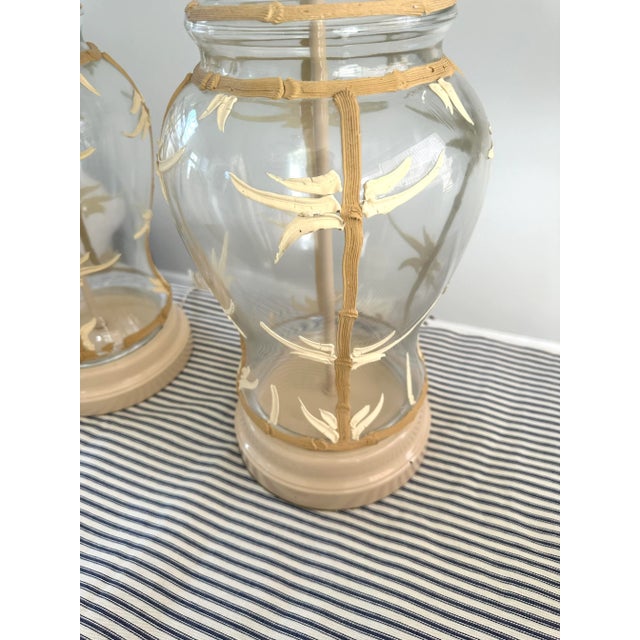 A large pair of glass lamps with tan faux bamboo icing. Cream colored base.