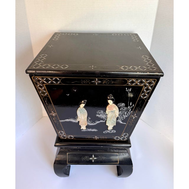 This vintage Asian black lacquer ice bucket on stand dates to the late 20th century, likely 1960s–1970s. The piece...