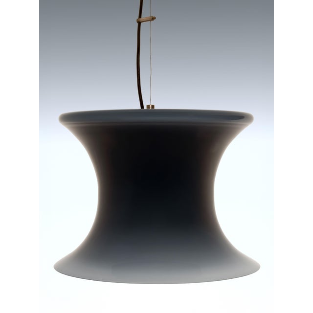 This opaline pendant lamp is an example of Italian mid-century glassmaking design. It is made from Murano glass and has a...
