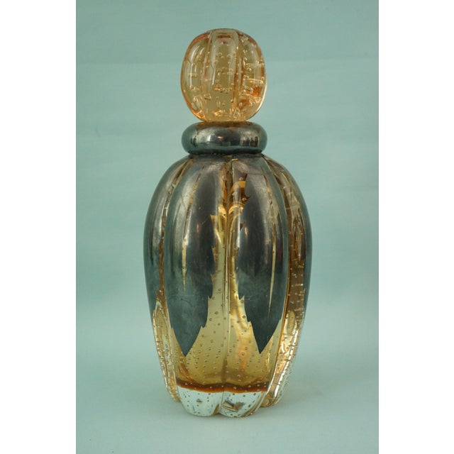 Item : Delightful, wide-ribbed bottle in Murano blown sommerso pulegoso glass, crafted by joining amber glass on the...