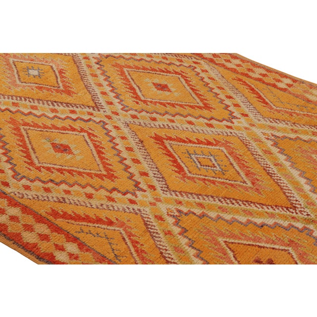 Hand knotted in wool originating from Morocco circa 1950-1960, this vintage mid-century Moroccan rug hails from the Berber...