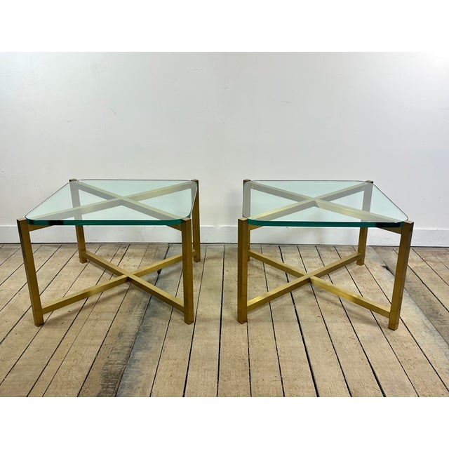 Pair of vintage side tables from the 1970s, combining a geometric, gilded brass frame with beautiful, thick, clear...