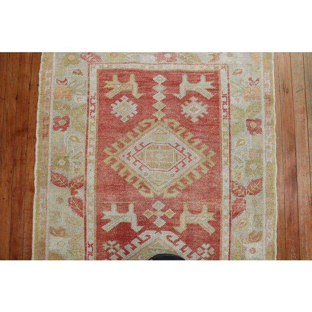 an early 20th-century Turkish Oushak Runner in soft coral red with a geometric design. You can find a few pigeons on the...
