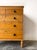 An antique Georgian English pine chest of drawers. Two short drawers over three long drawers with black knobs, on turned...