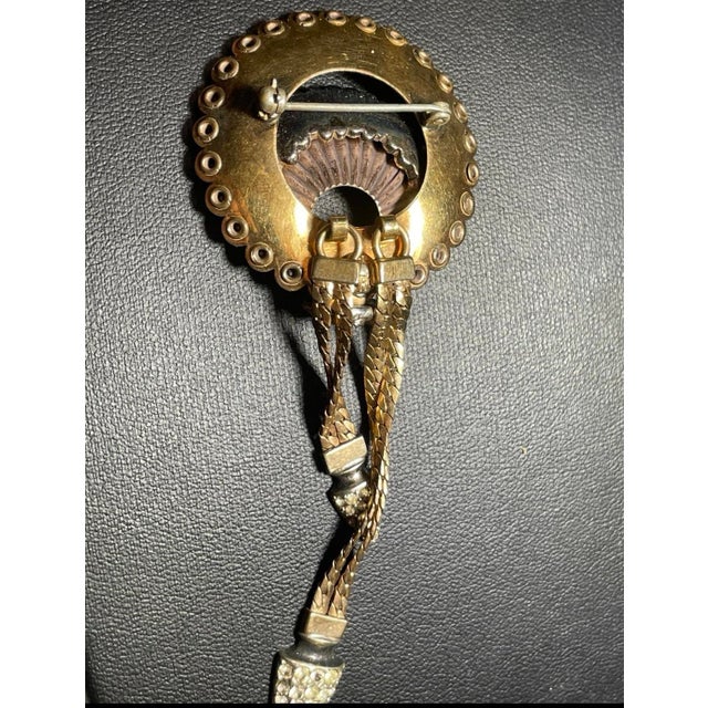 This 1940s Retro Modern costume brooch signed CRC and gold filled. It features a concave gold-tone disc with a scalloped...