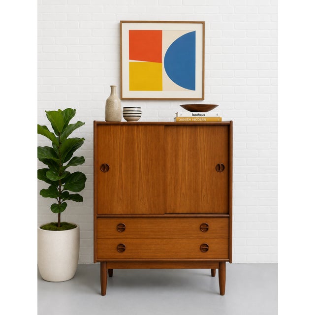 Vintage Mid Century Modern Danish teak cabinet featuring beautifully sculpted recessed pulls, clean architectural lines,...