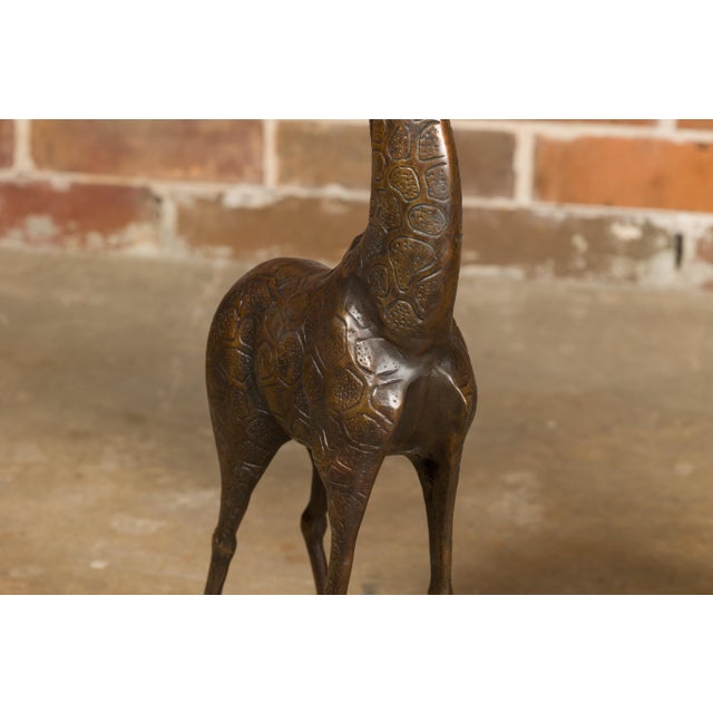 This charming pair of mid-20th-century American bronze giraffe sculptures exudes a playful and whimsical character, a...