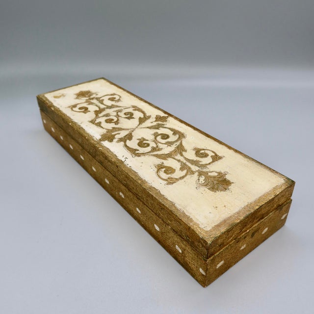 A charming Florentine giltwood box, hand-carved in low relief with a flourish of acanthus scrollwork across an ivory...