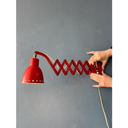 Red mid century Hala scissor wall lamp made out of metal. The lamp can easily be extended and folded with the scissor...