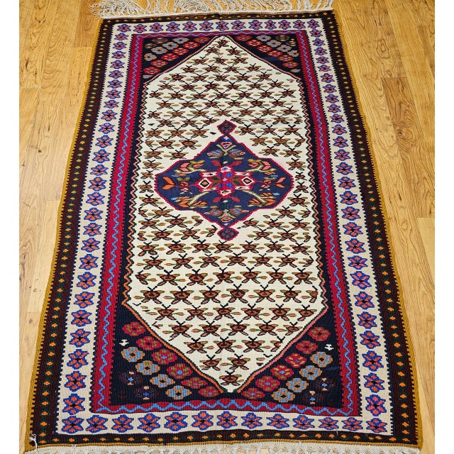 "A vintage Persian Senneh kilim area rug, handwoven in the mid-20th century in the culturally rich Kurdistan region of...