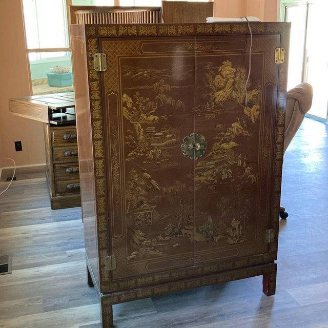 Vintage Drexel Heritage illuminated Chinoiserie cabinet characterized by its ornate hand-painted gold illustrations of...