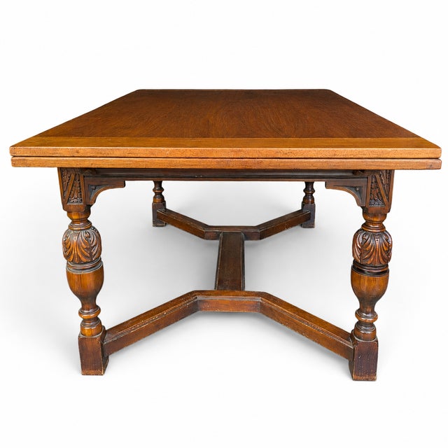 A substantial vintage walnut dining table inspired by Jacobean and Tudor refectory forms. The rectangular top is supported...