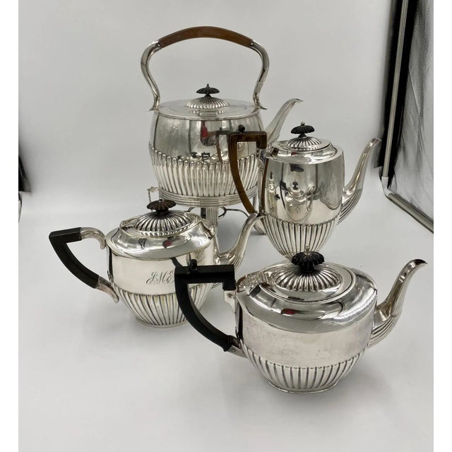 A Classic Adams design hot water urn with a coffee pot and 2 tea pots, England circa 1910. Marked EPNS. A gadrooned with...