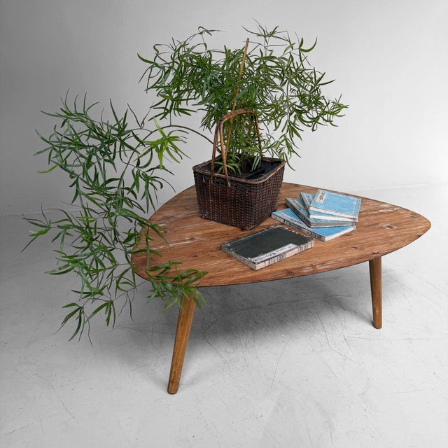 Vintage wooden coffee table, probably originating from Belgium. The table features an organically shaped top with soft,...