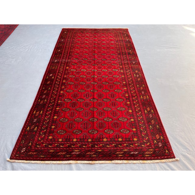 A vintage Afghan Ersari Turkmen rug in the classic Bokhara design — tidy rows of small Tekke-style güls cover a bright,...