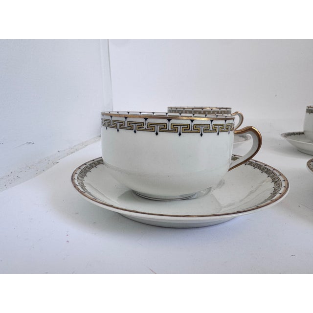 Set a four Haviland Limoges coffee cups and matching saucers. Albany pattern which Features a greek key pattern in black...
