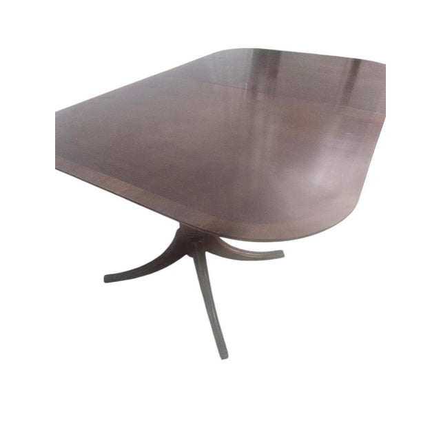 The Duncan Phyfe Mahogany Double Pedestal Dining Table is a beautifully crafted piece of furniture that adds a touch of...