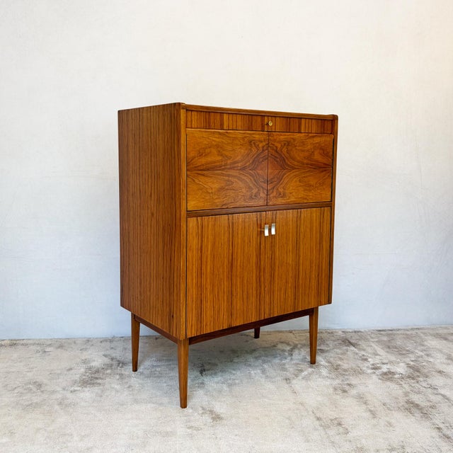 A metamorphic cocktail cabinet, circa 1950s-60s, bearing the retailer's label of Cox & Cox Ltd, The Furnishing Store,...