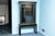 A vintage French Louis XVI glass front vitrine display cabinet made of ebonized mahogany and elaborately trimmed in gilt...